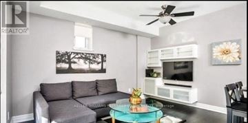 Toronto (Dovercourt-Wallace Emerson-Junction) townhouse for rent - A living room with a grey couch and a black chair.