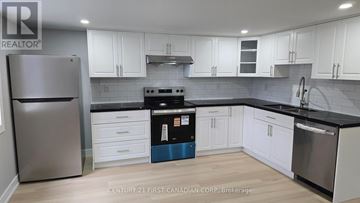 London East (East D) apartment for rent - A kitchen with white cabinets and a stainless steel refrigerator.