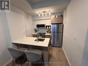 Burlington (Lasalle) townhouse for rent - A kitchen with a refrigerator, sink, and two chairs.