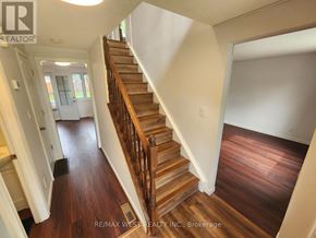 Windsor apartment for rent - A wooden staircase in a house with a white wall on the side.