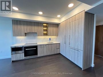 Toronto (Bayview Village) condo for rent - A modern kitchen with wooden cabinets and stainless steel appliances.