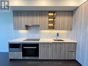 Toronto (Bayview Village) condo for rent - A modern kitchen with wooden cabinets and stainless steel appliances.