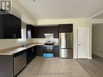 Oshawa (Central) triplex for rent - A kitchen with black cabinets and stainless steel appliances.