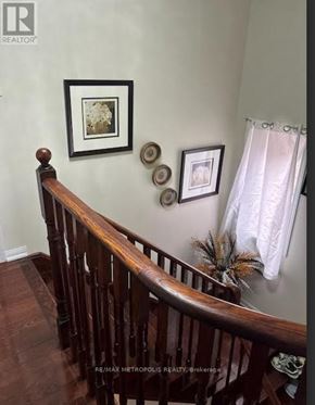 Oshawa (Taunton) apartment for rent - A wooden staircase with a white curtain on the side.