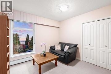 West Vancouver apartment for rent - A living room with a black couch, a wooden coffee table, and a painting on the wall.