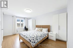 Toronto (L'amoreaux) townhouse for rent - A bedroom with a bed, nightstand, and chair.