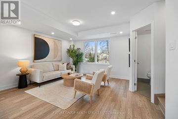Toronto (Islington-City Centre West) apartment for rent - A well-lit, spacious living room with a large painting on the wall and a view of the outdoors through the window.