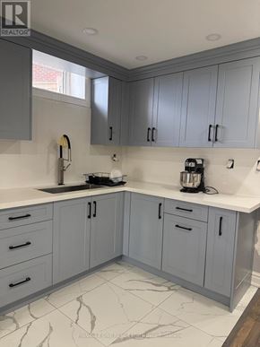 Clarington (Bowmanville) apartment for rent - A kitchen with grey cabinets and a marble floor.