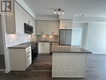 Richmond Hill (Langstaff) condo for rent - A kitchen with white cabinets and a black countertop.