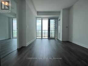 Richmond Hill (Langstaff) condo for rent - A spacious room with wooden floors and sliding glass doors.