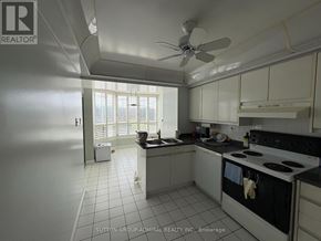 Vaughan (Crestwood-Springfarm-Yorkhill) condo for rent - A kitchen with white cabinets and a black stove top oven.