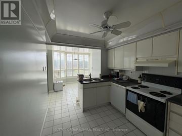 Vaughan (Crestwood-Springfarm-Yorkhill) condo for rent - A kitchen with white cabinets and a black stove top oven.