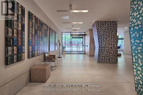 Toronto (Bay Street Corridor) condo for rent - A hallway with a series of framed pictures on the wall and a patterned column on the right.