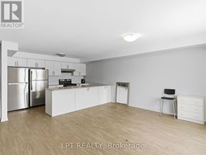 Barrie (Georgian Drive) townhouse for rent - A kitchen with white cabinets and a stainless steel refrigerator.
