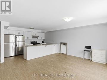 Barrie (Georgian Drive) townhouse for rent - A kitchen with white cabinets and a stainless steel refrigerator.