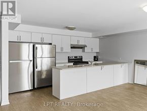 Barrie (Georgian Drive) townhouse for rent - A kitchen with white cabinets and stainless steel appliances.