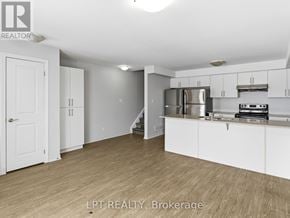 Barrie (Georgian Drive) townhouse for rent - A kitchen with white cabinets and a stainless steel refrigerator.