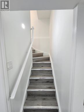 Caledon apartment for rent - A staircase with wooden steps and white railings.
