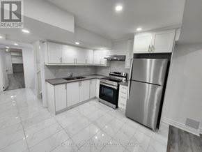 Caledon apartment for rent - A modern kitchen with white cabinets and a stainless steel refrigerator.