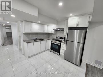 Caledon apartment for rent - A modern kitchen with white cabinets and a stainless steel refrigerator.