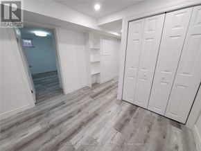 Oshawa (Centennial) apartment for rent - A room with white walls and a wooden floor with a set of white cupboards.