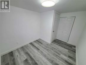 Oshawa (Centennial) apartment for rent - A room with a white door and grey wood flooring.
