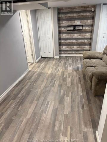 Windsor apartment for rent - A living room with a grey couch and a wooden floor.