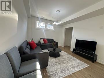 Toronto (Oakwood Village) multi-family for rent - A living room with a grey couch and a black television.