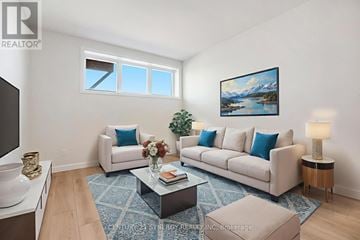 North Stormont duplex for rent - A living room with a white couch, a coffee table, and a painting on the wall.