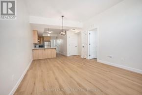 North Stormont multi-family for rent - A spacious room with wooden flooring and a kitchen area in the background.