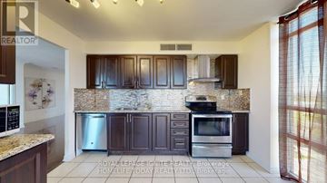 Toronto (Dorset Park) condo for rent - A kitchen with brown cabinets and a granite countertop.