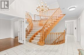 Markham (Village Green-South Unionville) apartment for rent - A wooden staircase with a chandelier in a white room.