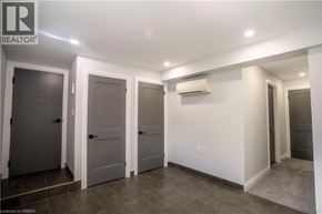 Brantford apartment for rent - A room with a white wall and a grey floor with a door on the left.