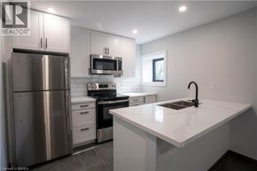 Brantford apartment for rent - A modern kitchen with a stainless steel refrigerator and a white countertop.