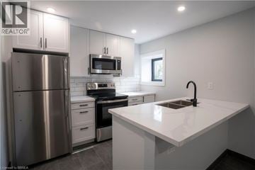 Brantford apartment for rent - A modern kitchen with a stainless steel refrigerator and a white countertop.