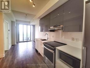 Toronto (Don Valley Village) condo for rent - A modern kitchen with dark wood floors and white appliances.