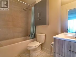 Toronto (Don Valley Village) condo for rent - A white toilet sits next to a bathtub in a bathroom.