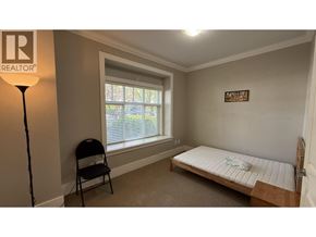 Burnaby apartment for rent - A bedroom with a bed, chair, and window.