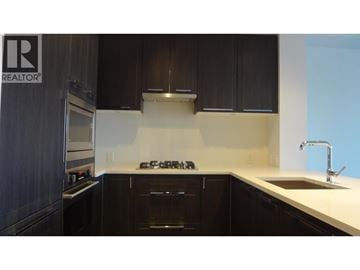 Vancouver apartment for rent - A kitchen with dark wood cabinets and a white countertop.