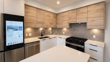 Abbotsford apartment for rent - A modern kitchen with wooden cabinets and a white countertop.