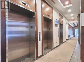 Toronto (Bendale) condo for rent - A hallway with elevators and a realtor sign.