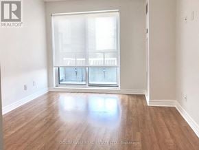 Toronto (Bendale) condo for rent - A room with wooden floors and a large window with blinds.