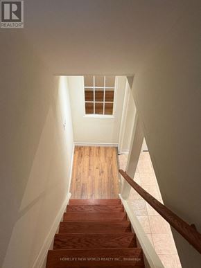 Markham (Berczy) apartment for rent - A staircase with wooden steps and a window in the distance.