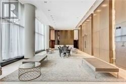 Toronto (Bayview Village) condo for rent - A modern living room with a glass table and a bench.