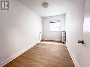 Toronto (Briar Hill-Belgravia) apartment for rent - A room with a wooden floor and white walls.