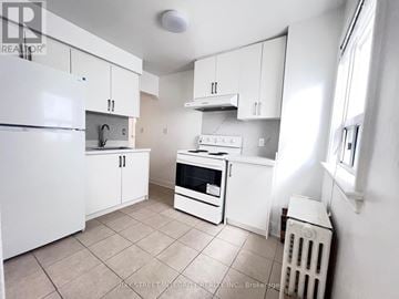 Toronto (Briar Hill-Belgravia) apartment for rent - A small kitchen with white appliances and cabinets.