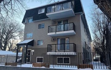 Saskatoon apartment for rent - A modern two-story apartment building with a balcony on the second floor.