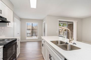 Wilmington apartment for rent - A kitchen with white cabinets and a black stove top oven.