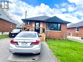 Hamilton (Hill Park) apartment for rent - A silver car is parked in front of a brick house with a license plate that reads "CFJ-377".