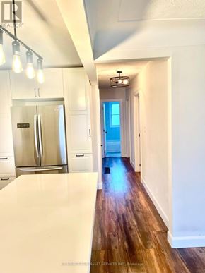 Hamilton (Hill Park) apartment for rent - A long hallway with a refrigerator on the left and a door at the end.